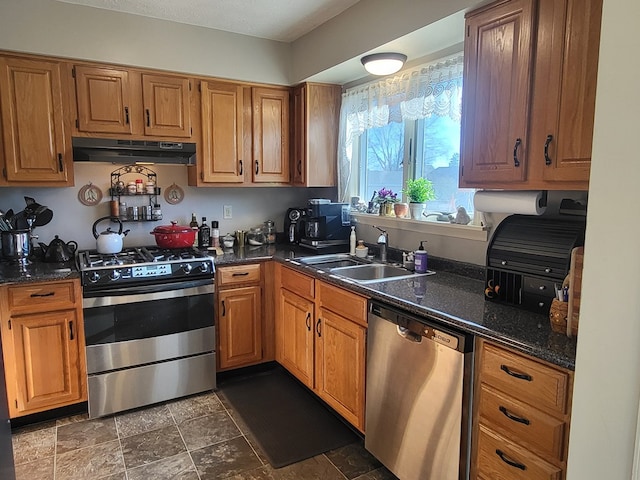 kitchen featuring dark stone countertops, sink, and appliances with stainless steel finishes