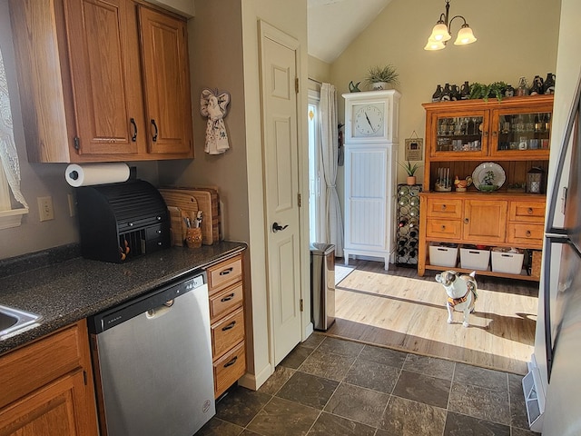 kitchen featuring hanging light fixtures, vaulted ceiling, appliances with stainless steel finishes, and an inviting chandelier