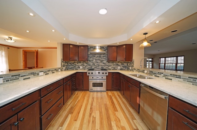 kitchen featuring appliances with stainless steel finishes, sink, pendant lighting, and kitchen peninsula