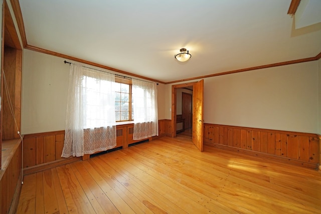 empty room with crown molding and light wood-type flooring