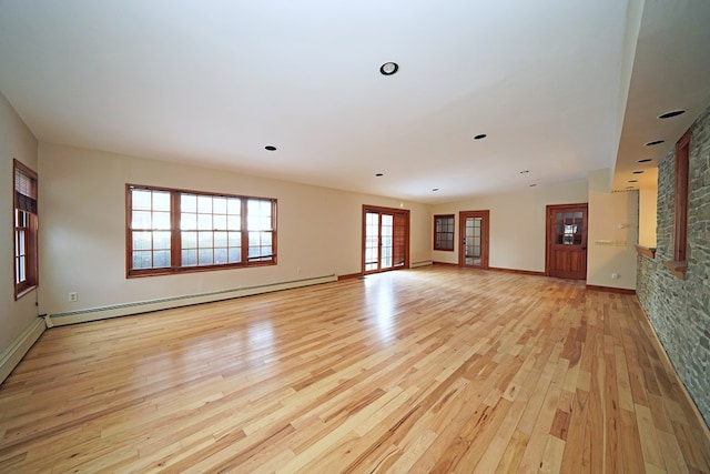 spare room featuring a baseboard radiator and light hardwood / wood-style floors