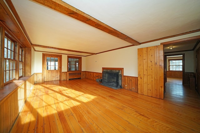 unfurnished living room with hardwood / wood-style flooring, ornamental molding, and beam ceiling