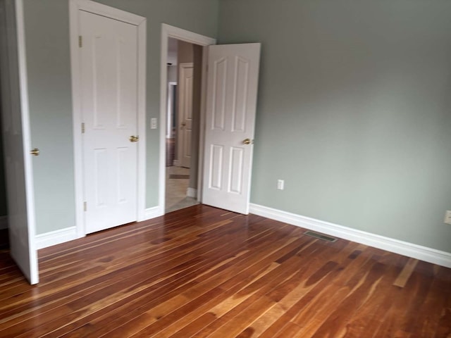 unfurnished bedroom with dark hardwood / wood-style floors