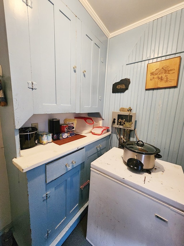 kitchen featuring white cabinetry, crown molding, and blue cabinetry