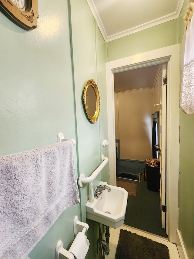 bathroom with crown molding, tile patterned flooring, and sink