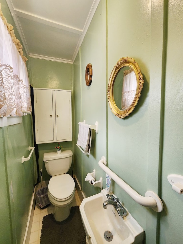 bathroom with crown molding, tile patterned floors, toilet, and sink