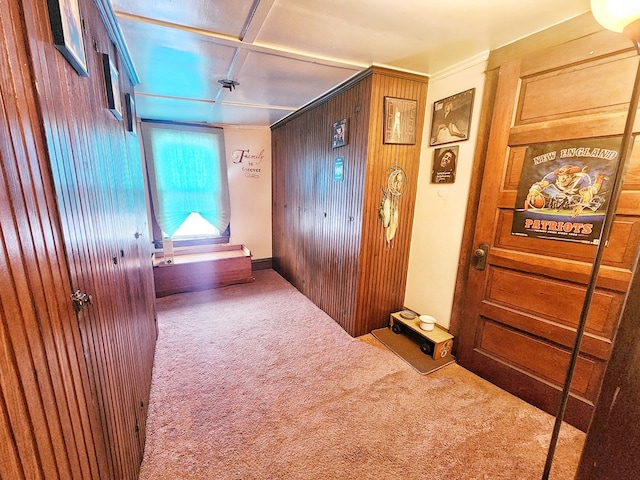 hallway with carpet floors and wooden walls