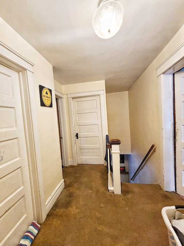 hall featuring dark colored carpet