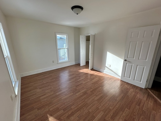 unfurnished bedroom featuring dark wood-type flooring and a closet