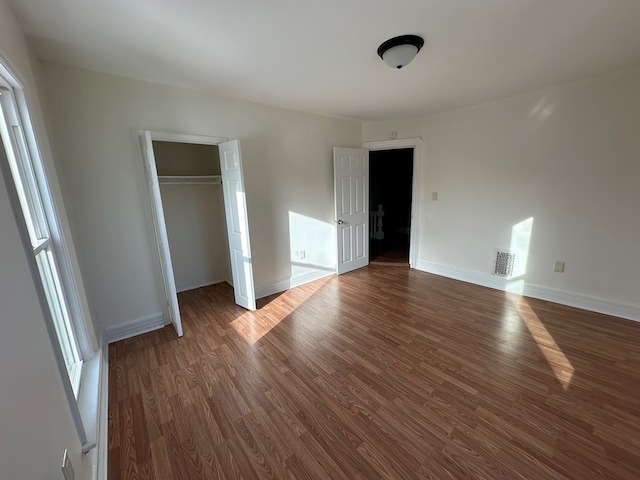 unfurnished bedroom featuring dark hardwood / wood-style flooring and a closet