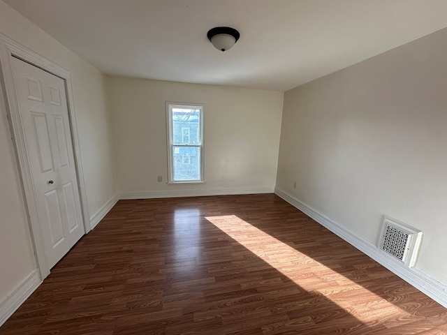 empty room with dark wood-type flooring