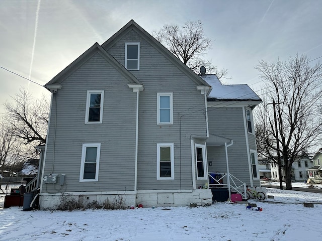 view of snow covered back of property