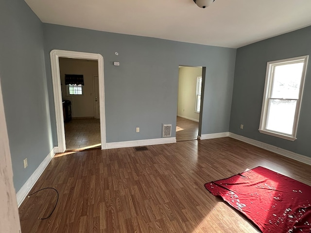 empty room featuring hardwood / wood-style flooring and a healthy amount of sunlight