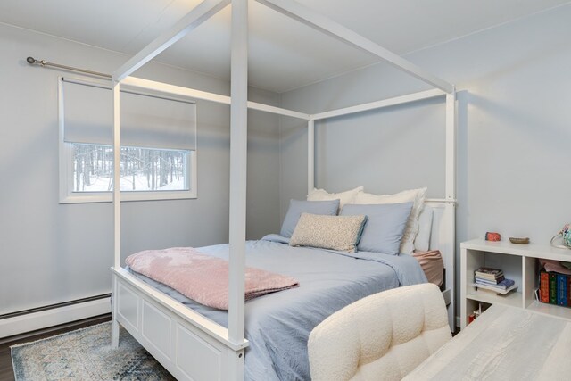 bedroom featuring hardwood / wood-style flooring and baseboard heating