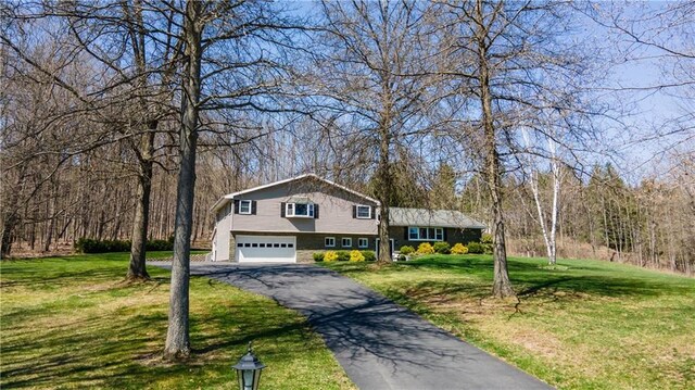 split level home featuring a garage and a front lawn