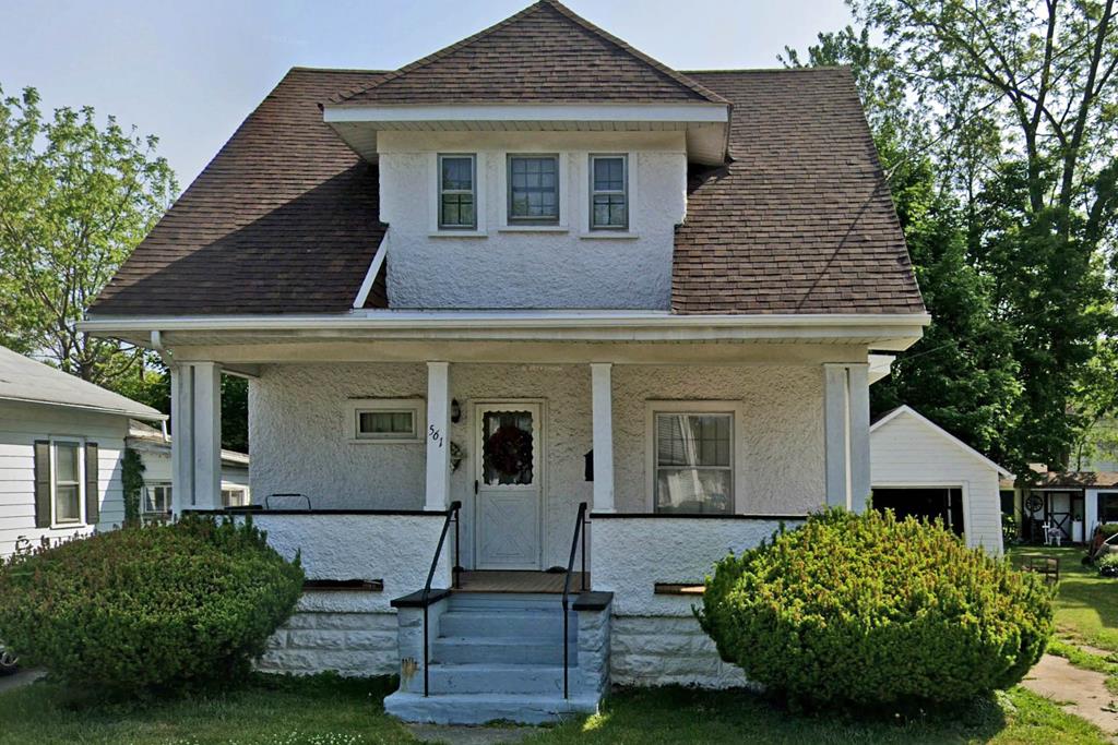 bungalow-style home with a garage, an outdoor structure, and covered porch