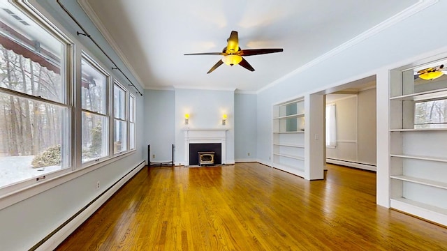 unfurnished living room featuring a baseboard radiator, hardwood / wood-style floors, crown molding, and built in shelves