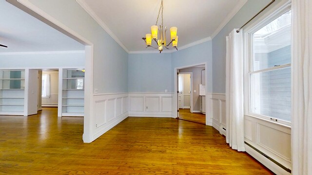 unfurnished dining area featuring an inviting chandelier, hardwood / wood-style floors, crown molding, and a baseboard heating unit