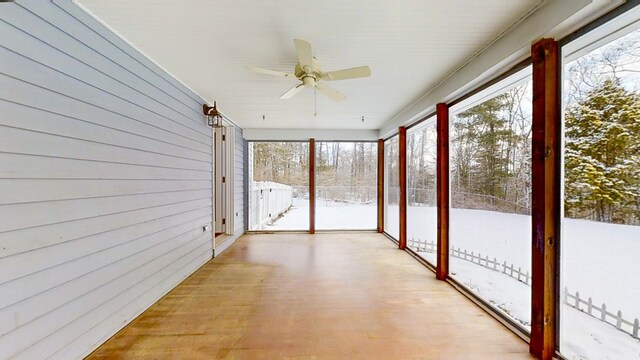 unfurnished sunroom with ceiling fan