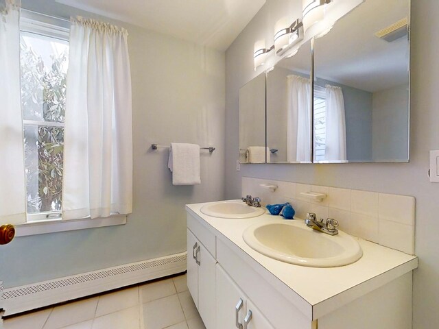 bathroom featuring tile patterned flooring, vanity, backsplash, and baseboard heating