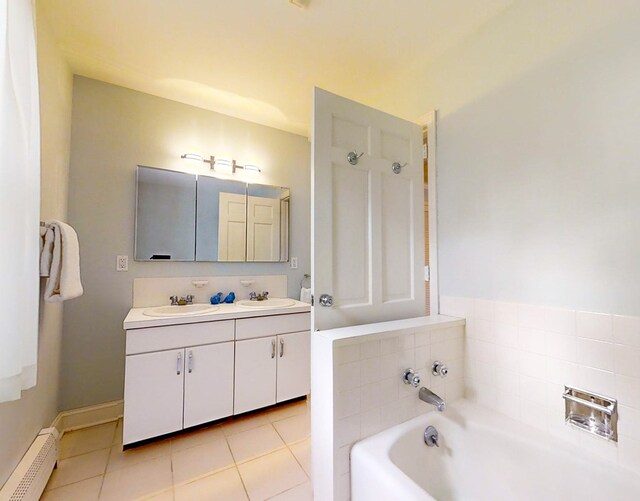 bathroom with vanity, a tub to relax in, tile patterned floors, and baseboard heating