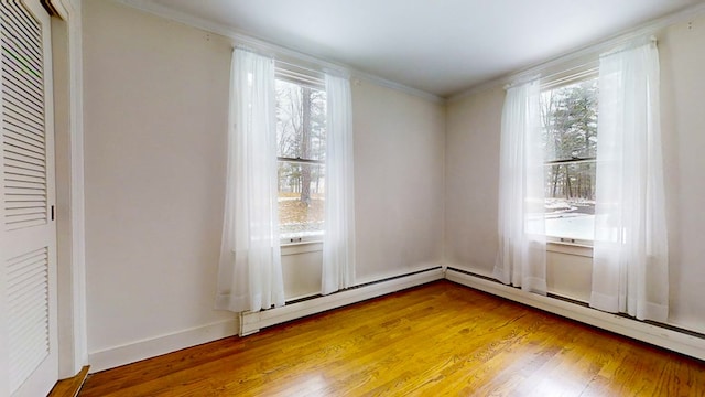 interior space with crown molding, hardwood / wood-style floors, and baseboard heating