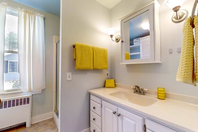 bathroom featuring vanity, radiator, a wealth of natural light, and an enclosed shower