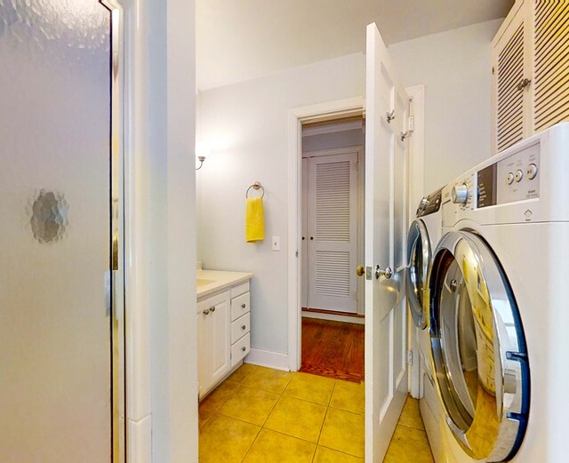 laundry room featuring light tile patterned flooring and washing machine and clothes dryer