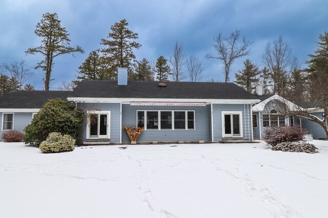 view of snow covered rear of property