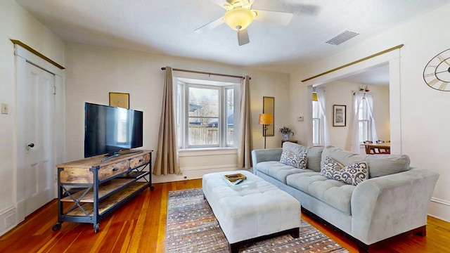 living room with dark wood-type flooring and ceiling fan