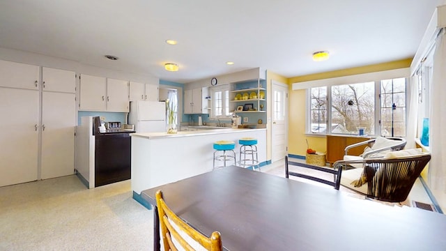 kitchen featuring white cabinetry, sink, and white fridge