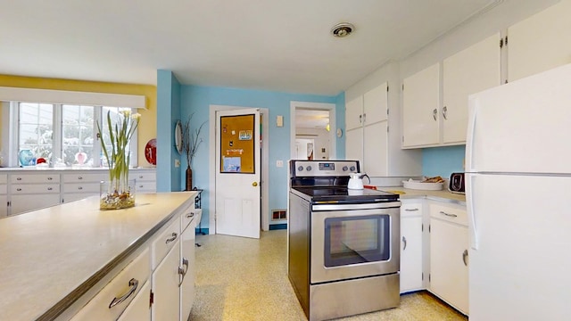 kitchen featuring stainless steel range with electric stovetop, white cabinets, and white refrigerator