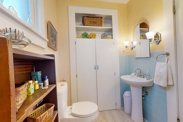 bathroom featuring tile walls, wood-type flooring, and toilet