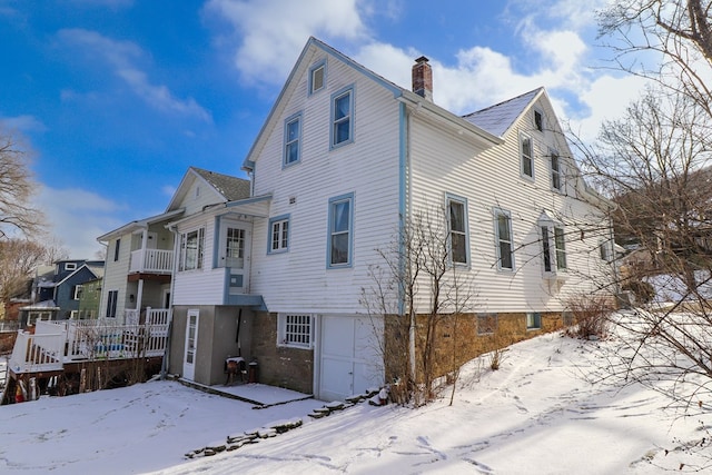 snow covered property with a garage