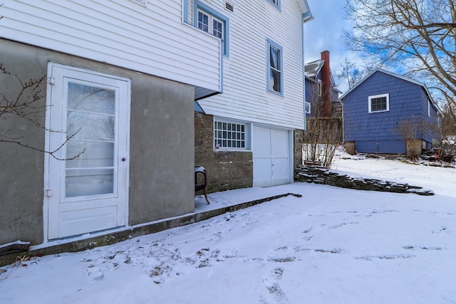 snow covered property featuring a garage