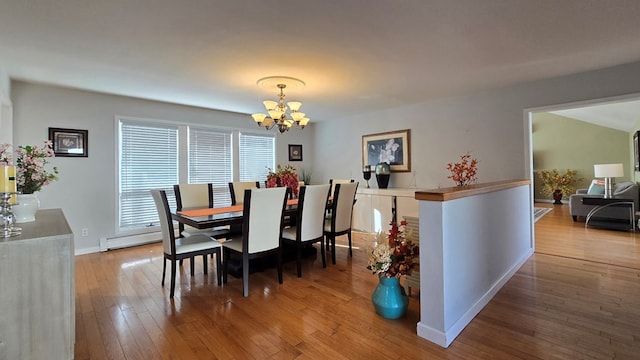 dining room featuring a notable chandelier, wood-type flooring, and baseboard heating