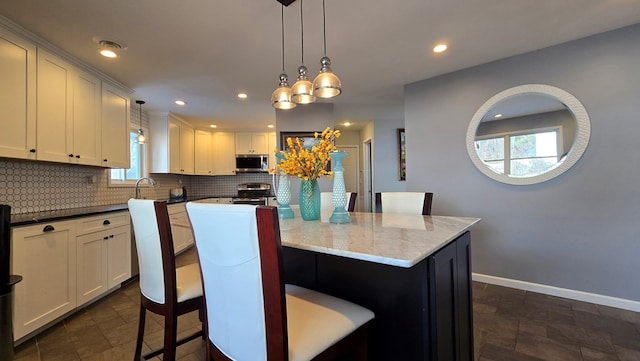 kitchen with stainless steel appliances, a center island, and decorative light fixtures