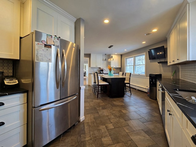 kitchen with white cabinetry, stainless steel fridge, baseboard heating, and decorative light fixtures