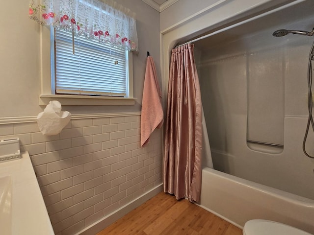 full bathroom featuring shower / tub combo with curtain, wood-type flooring, tile walls, vanity, and toilet