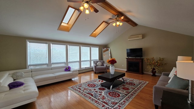 living room with beamed ceiling, a skylight, light hardwood / wood-style flooring, and an AC wall unit