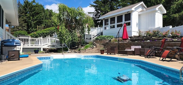 view of pool with a patio area, a sunroom, and a deck