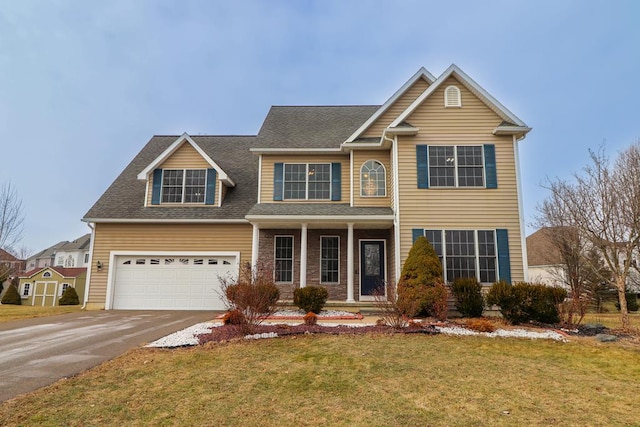 view of front facade with a garage, a front lawn, and covered porch