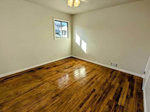 spare room featuring dark wood-type flooring and ceiling fan