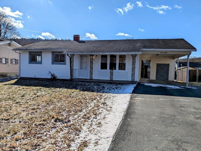 single story home featuring a carport and a shed