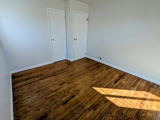 unfurnished bedroom featuring dark wood-type flooring