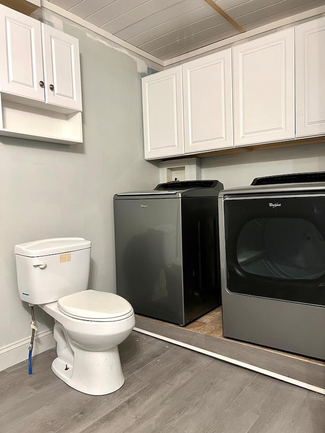 washroom with dark hardwood / wood-style flooring, wood ceiling, and washing machine and dryer