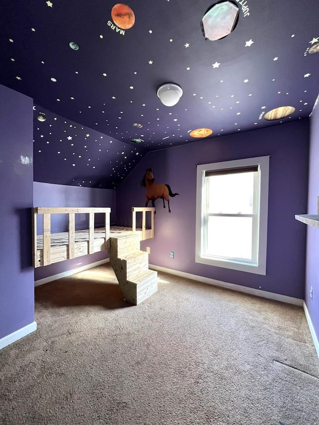 carpeted home theater room featuring vaulted ceiling