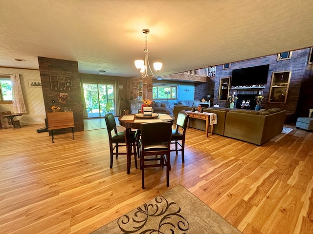 dining area with wood-type flooring, a textured ceiling, and a notable chandelier