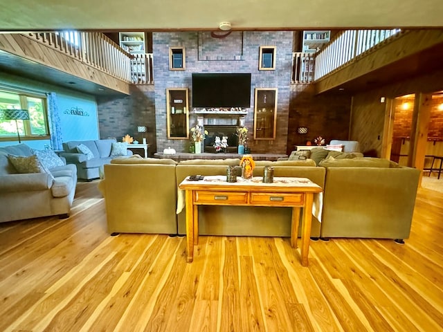 living room featuring a high ceiling, hardwood / wood-style flooring, and a large fireplace