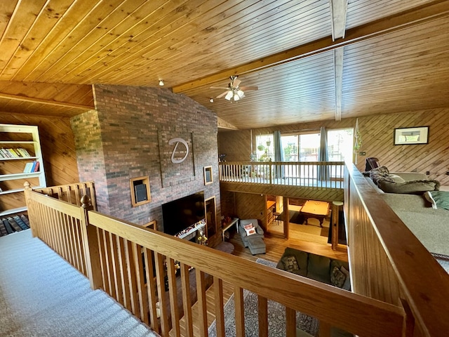 interior space featuring hardwood / wood-style floors, wooden walls, vaulted ceiling with beams, ceiling fan, and wood ceiling